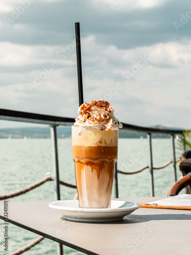 A glass of coffee and ice cream with whipped cream and cocoa at the lake Balaton.