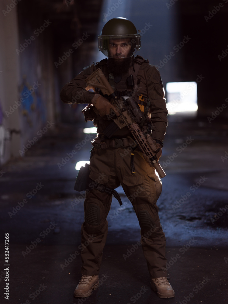 Army soldier in Combat Uniforms with an assault rifle and combat helmet night mission dark background. Blue and purple gel light effect. Army soldier in Combat Uniforms with an assault rifle and combat helmet night mission dark background. Blue and purple gel light effect.