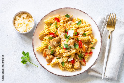 Pasta with turkey or chicken, vegetables and parmesan. Top view at white.