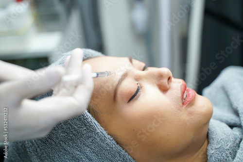 Closeup and crop hands of beauty doctor in medical grove holding beauty skin syringe injecting the customer's face. Beauty skin concept © Atiwat