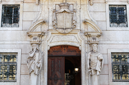 Facade of a historical building in the old town of Lisbon, Portugal, Europe. Statues, sculptures, figures, and beautiful ornaments decorate an old house's entrance. Ancient stone statues.