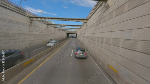 Mini cooper driving along 27 de Febrero avenue  in Santo Domingo city. Aerial tracking drone fpv photo