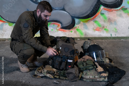 Valokuva Army body armor, helmet and ammunition, Kalashnikov assault rifle with matrons and first aid tourniquet composition on brown wood