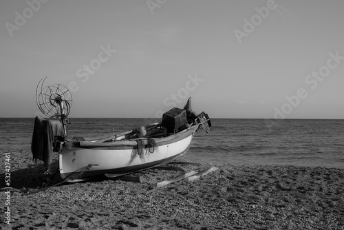 Boat on the beach.
Fishing boat with its equipment on the beach; black and white photo.