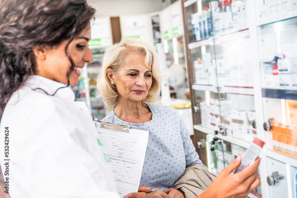 Pharmacist selling medications to senior female customer in the pharmacy store. Pharmacist selling medications to senior female customer in the pharmacy store.