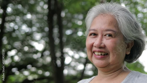 Asian elderly woman exercising in the park She smiled happily. The concept of health care of seniors. Exercise for health in retirement