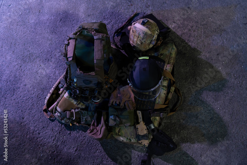 Schilderij op canvas Army body armor, helmet and ammunition, Kalashnikov assault rifle with matrons and first aid tourniquet composition on brown wood