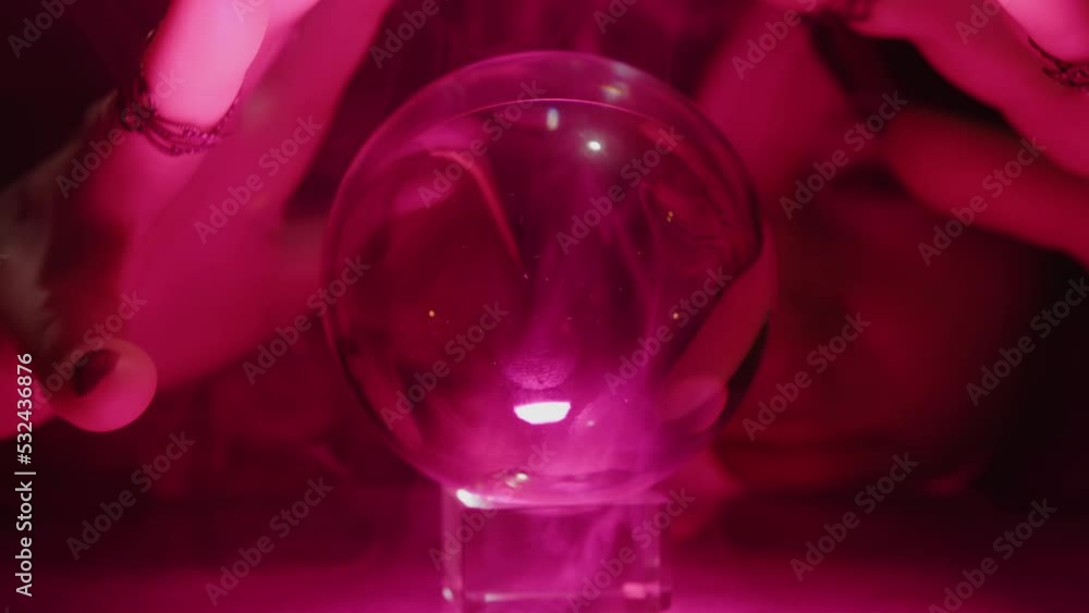 Medium makes magical movements with his hands looking at crystal ball, prediction, clairvoyance. Medium makes magical movements with his hands looking at crystal ball, prediction, clairvoyance.