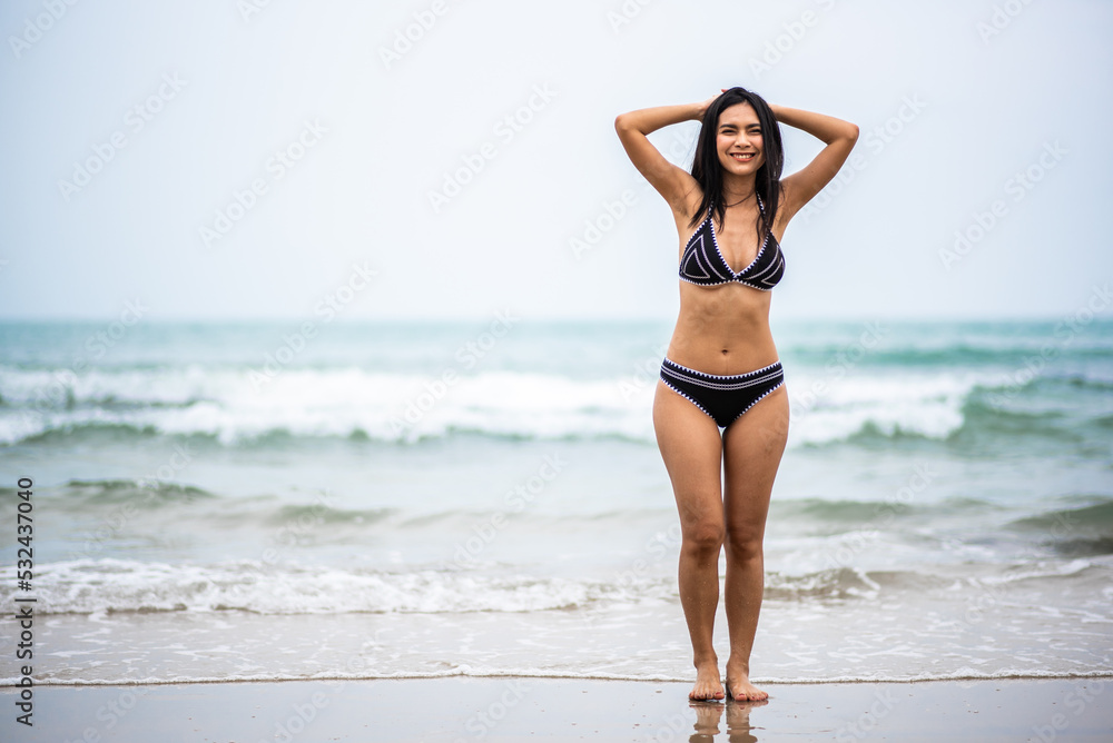Portrait beautiful young asian woman with black bikini on the beach. Holiday and summer travel concept Portrait beautiful young asian woman with black bikini on the beach. Holiday and summer travel concept