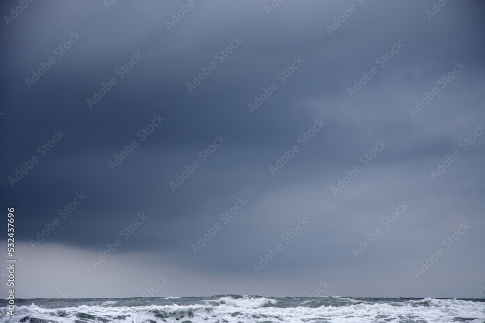 dark cloud in stormy grey sky over rough sea landscape