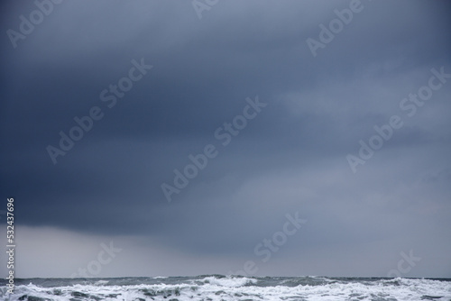 dark cloud in stormy grey sky over rough sea landscape
