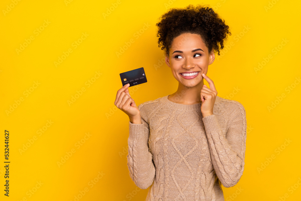 Photo of think millennial brunette lady hold card look promotion wear sweater isolated on yellow color background Photo of think millennial brunette lady hold card look promotion wear sweater isolated on yellow color background