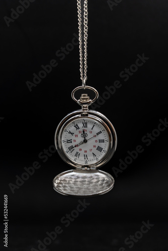 An old pocket watch on black background, copy space