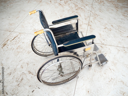 Retro empty wheel chair on dusty white floor