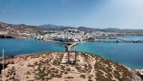 Aerial view of the famous Portara marble gate with the white houses of the city of Naxos island, Cyclades, Greece, during a sunny summer day photo