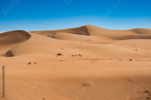Landscape photo of desert and sand dune under the clear blue sky in Dubai, UAE