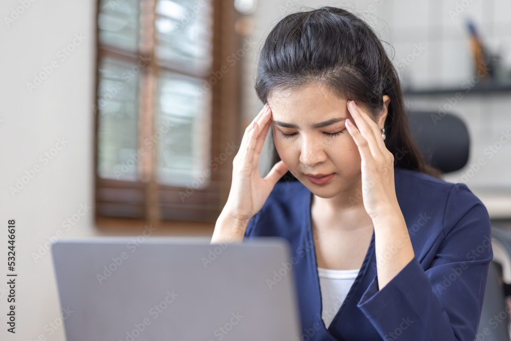Asian women are stressed while working on laptop, Tired asian businesswoman with headache at workplace, feeling sick at work, copy space Asian women are stressed while working on laptop, Tired asian businesswoman with headache at workplace, feeling sick at work, copy space