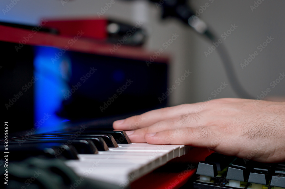 close up unrecognizable male hands on the keys of an electric piano in a home music studio close up unrecognizable male hands on the keys of an electric piano in a home music studio