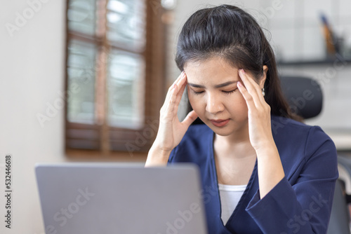 Asian women are stressed while working on laptop, Tired asian businesswoman with headache at workplace, feeling sick at work, copy space