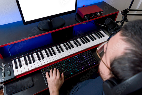 top view of music producer working typing on computer keyboard in his home music studio