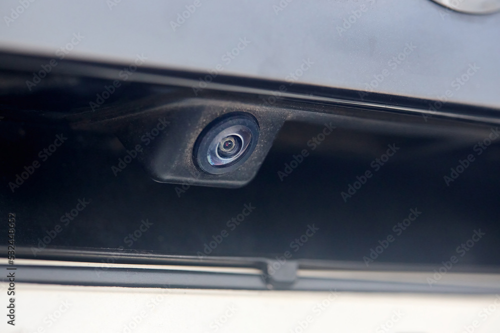Luxury car rear view camera for parking assistance selective focus close up with sunflare and copyspace. Concept of safety car driving while parking process. Assist device equipment in modern cars. Luxury car rear view camera for parking assistance selective focus close up with sunflare and copyspace. Concept of safety car driving while parking process. Assist device equipment in modern cars.