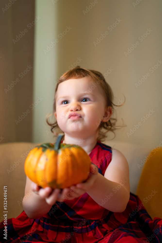 Fototapeta premium happy baby with a pumpkin for Halloween home