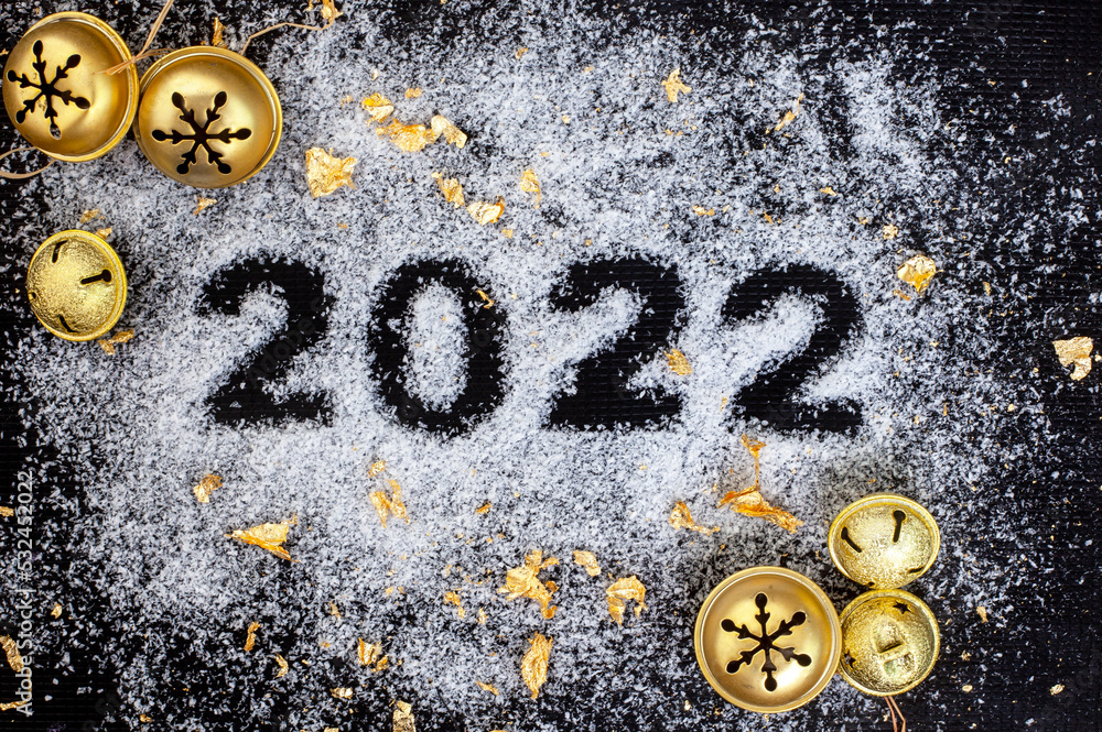 Festive season 2022, snow with 2022 on black surface with gold décor Festive season 2022, snow with 2022 on black surface with gold décor