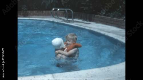 Pool Playtime 1969 - A girl plays with her younger siblings in a pool in Canoga Park, Californai in 1969.  photo