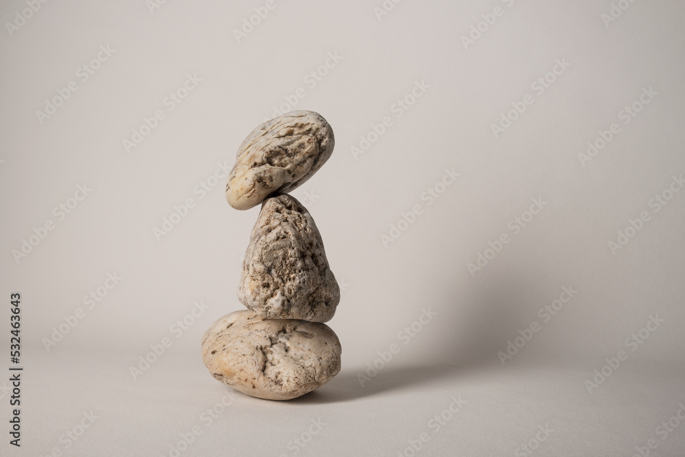 three balancing pebbles on neutral background
