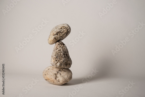 Obraz na płótnie three balancing pebbles on neutral background w salonie