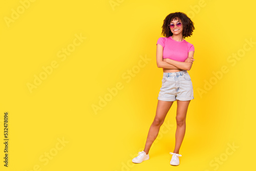 Full length photo of gorgeous cheerful girl crossed arms empty space isolated on yellow color background