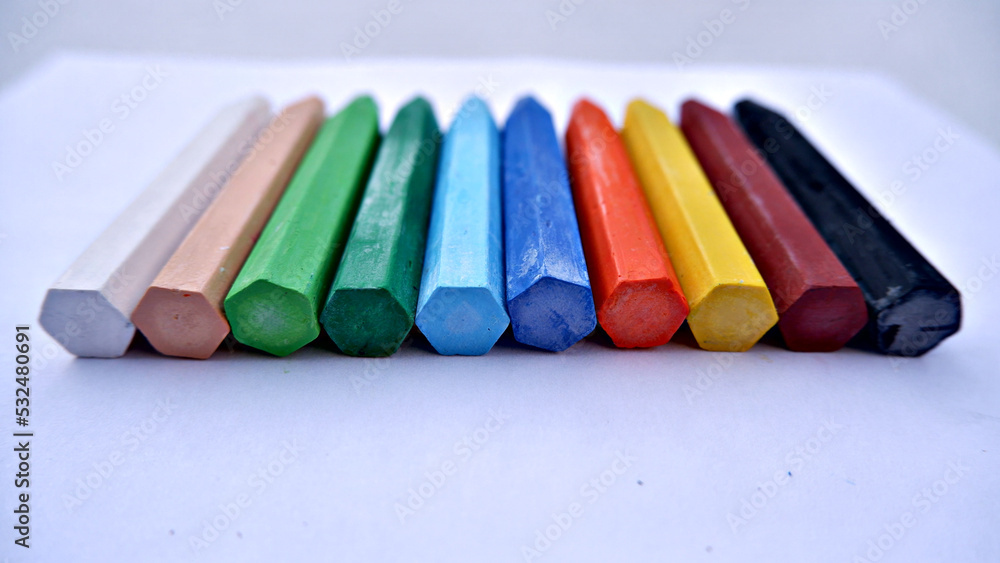 colorful pastel pencils on white paper background colorful pastel pencils on white paper background