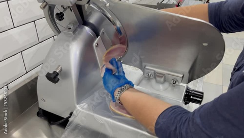 Ham being sliced on a slicer machine