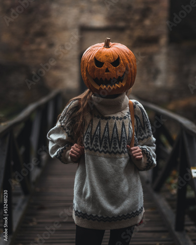 Happy Halloween. Photography with women and pumpkin in dark and moody conditions at abandoned old Czech castle Lukov. Place with nice vibes and old wooden bridge.
