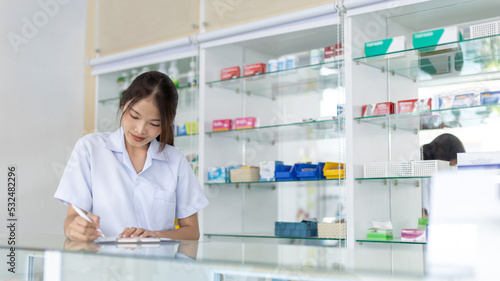 Pharmacist working in a pharmacy, Consultation and medical advice, All kinds of generic household drugs and pharmaceutical products on the shelf, Service and assistance to patients, Pharmacy.