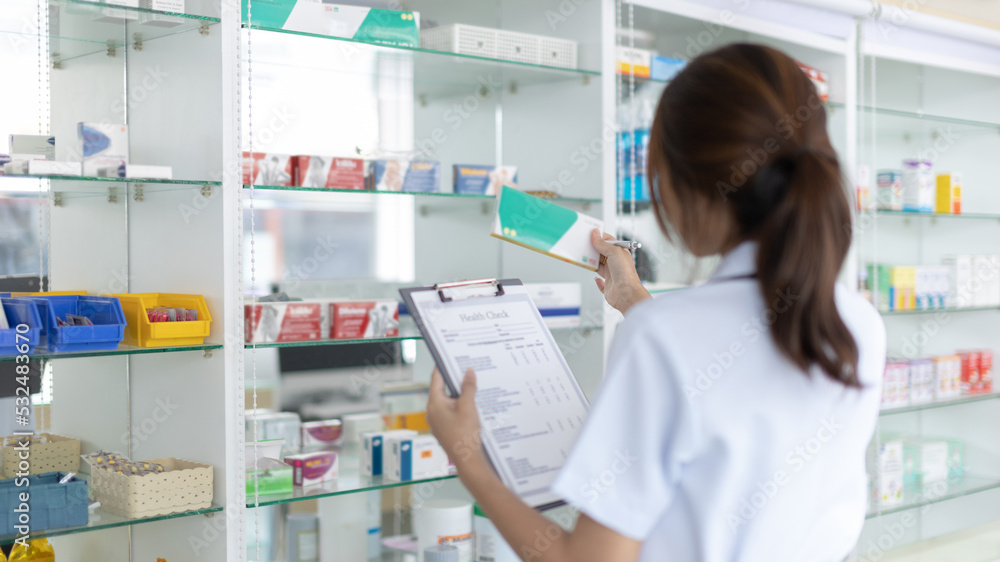 Pharmacist women are supplying prescription drugs to customers, Pharmacists work in a pharmacy, Drug store shelf with prescription medication, Clipboard at the hospital pharmacy, Community Pharmacy.