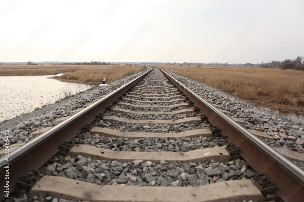 Railroad tracks on a bright cloudy day.