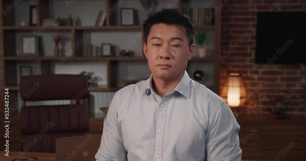Portrait of serious Chinese businessman standing in the home office Portrait of serious Chinese businessman standing in the home office