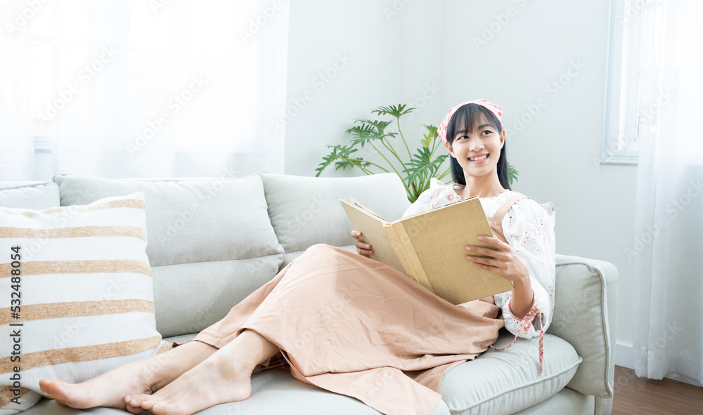 White cozy bed and asian beautiful girl, reading a book, concepts of home and comfort, place for text.Book worm love read book .Charming woman on cozy sofa interior.Vacation activity in home. White cozy bed and asian beautiful girl, reading a book, concepts of home and comfort, place for text.Book worm love read book .Charming woman on cozy sofa interior.Vacation activity in home.