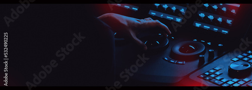 Edit video production control panel in studio. Editor editing and grade film in movie post room. Telecine control machine and man hand editing or adjusting color on digital video in post production.