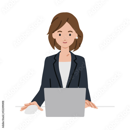 デスクで座ってPCを使っているスーツの女性