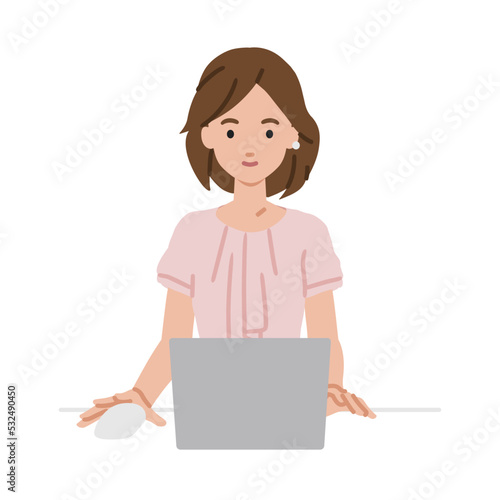 デスクで座ってPCを使っているオフィスカジュアルの女性