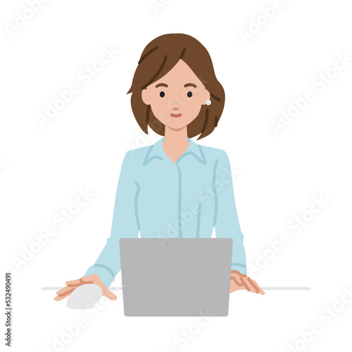 デスクで座ってPCを使っているブラウスの女性