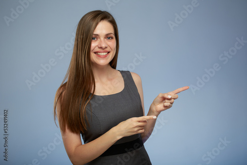 Smiling business woman pointing with two fingers side away at copy space. isolated portrait.