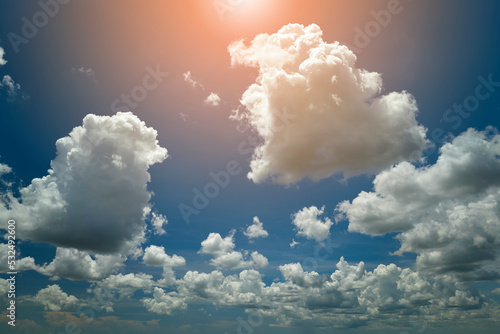 White puffy cumulus clouds on summer blue sky