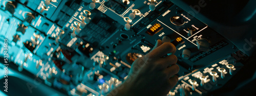 Photography CU Commercial aircraft pilots adjusting radio channel parameters during the flight at high altitude
