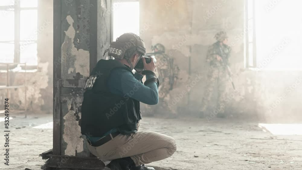 Rear of professional male correspondent in bulletproof vest an helmet