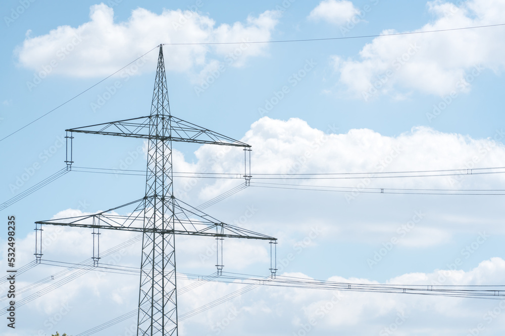 Electricity pylon for over land power transmission of high voltage in front of blue sky Electricity pylon for over land power transmission of high voltage in front of blue sky