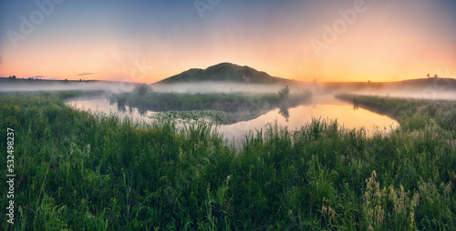 Beautiful spring sunrise over river banks. the sun s rays break through the mist. Morning fog