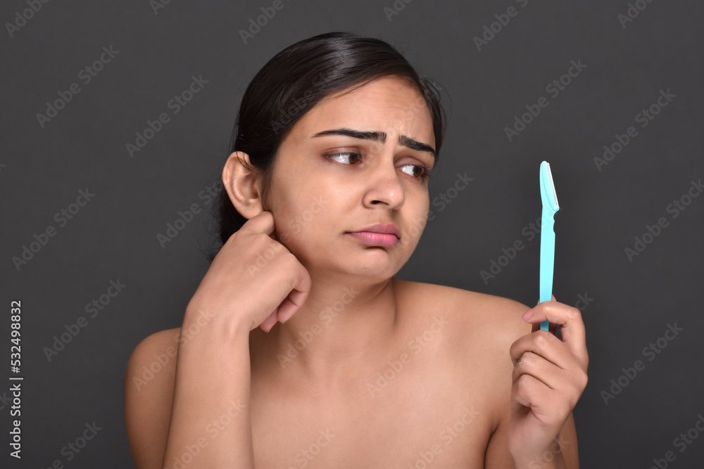 Obraz premium A young woman holding an eyebrow trimmer